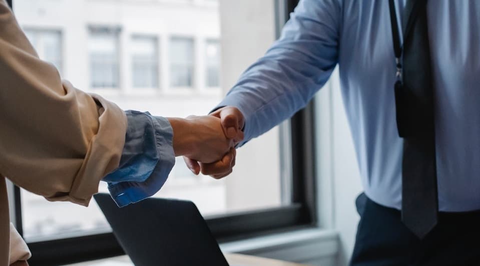 Dos profesionales se estrechan la mano en una oficina.